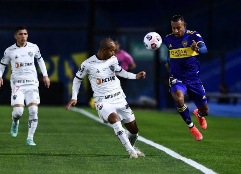 Sebastián Villa se lleva la pelota ante la atenta mirada del defensor de Atlético Mineiro.